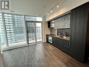 Vaughan (Vaughan Corporate Centre) condo for rent - A modern kitchen with dark wood floors and a large window overlooking a cityscape.
