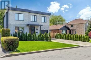 Toronto (Maple Leaf) apartment for rent - A modern two-story house with a well-manicured lawn and a clear blue sky above.