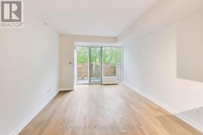 Toronto (Birchcliffe-Cliffside) condo for rent - A spacious room with wooden flooring and a sliding glass door leading to a balcony.