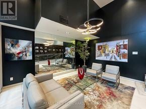 Toronto (Birchcliffe-Cliffside) condo for rent - A modern living room with a glass table and a large painting on the wall.