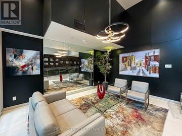Toronto (Birchcliffe-Cliffside) condo for rent - A modern living room with a glass table and a large painting on the wall.