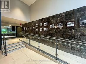Toronto (Birchcliffe-Cliffside) condo for rent - A hallway with a marble wall and a series of framed pictures.