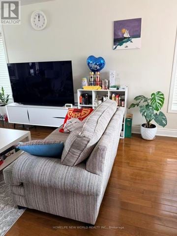 Cobourg townhouse for rent - A living room with a grey couch and a television.