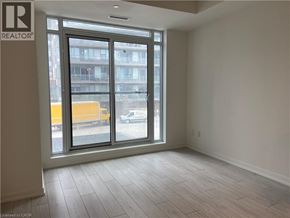 Kitchener condo for rent - A room with a large window and wooden flooring.