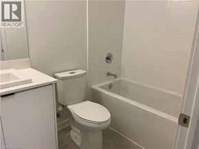 Kitchener condo for rent - A white toilet and sink in a small bathroom.