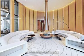 Toronto (Bay Street Corridor) condo for rent - A modern living room with a circular patterned rug and a large vase in the middle.