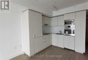 Toronto (Bay Street Corridor) condo for rent - A white kitchen with a microwave, oven, and sink.