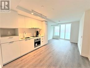 Toronto (Newtonbrook East) condo for rent - A spacious kitchen with white cabinets and a wooden floor.