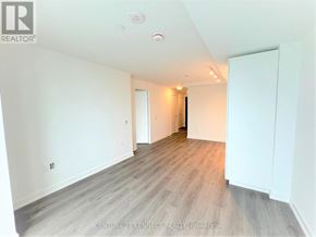Toronto (Newtonbrook East) condo for rent - A spacious room with wooden flooring and white walls.