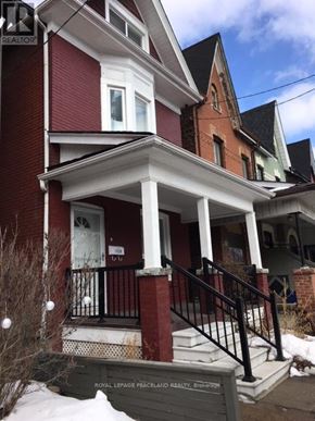 Toronto (South Riverdale) apartment for rent - A red house with a sign in front that says Royal LePage Peaceland Realty.