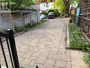 Toronto (South Riverdale) apartment for rent - A narrow alley with a brick pathway and a fence on the right side.