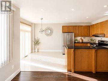 Vaughan (Patterson) apartment for rent - A kitchen with wooden cabinets and a black countertop.
