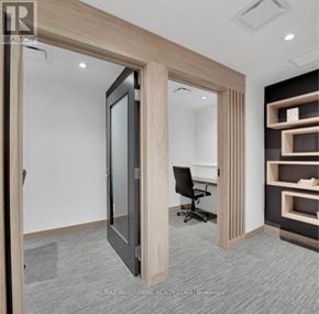 Oakville (Br Bronte) condo for rent - A room with a black chair and a wooden door.