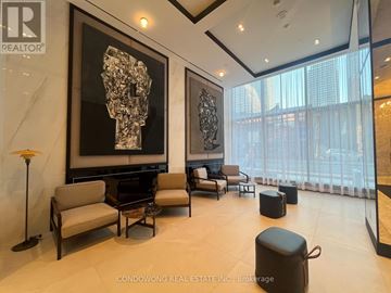 Toronto (Bay Street Corridor) condo for rent - A living room with a large abstract painting on the wall and a view of the city outside the window.