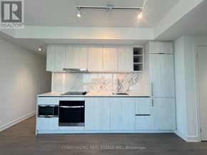 Toronto (Bay Street Corridor) condo for rent - A modern kitchen with white cabinets and a marble backsplash.