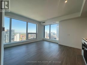Toronto (Bay Street Corridor) condo for rent - A spacious room with a view of the cityscape through large windows.