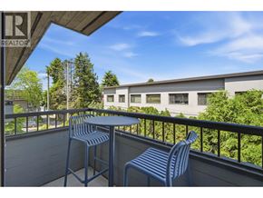 Vancouver apartment for rent - A balcony with a table and two chairs overlooks a building and trees.