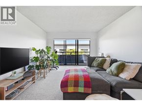 Vancouver apartment for rent - A living room with a grey couch and a flat screen TV.