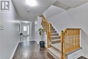 Brampton (Fletcher's Meadow) apartment for rent - A wooden staircase with a beige carpeted runner leads up to a white ceiling.