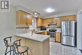 Brampton (Fletcher's Meadow) apartment for rent - A kitchen with wooden cabinets and a white countertop.