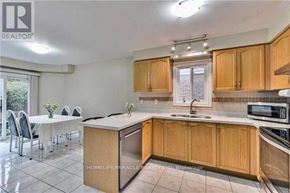 Brampton (Fletcher's Meadow) apartment for rent - A kitchen with wooden cabinets and a white countertop.