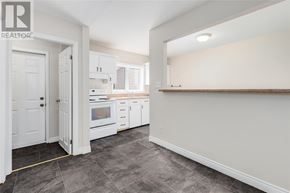 St. John's apartment for rent - A kitchen with white cabinets and a grey floor.