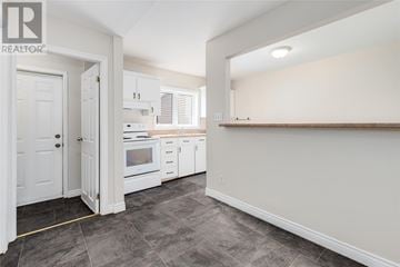 St. John's apartment for rent - A kitchen with white cabinets and a grey floor.