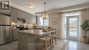 Toronto (Downsview-Roding-Cfb) townhouse for rent - A modern kitchen with stainless steel appliances and a large island.