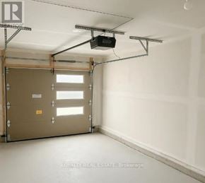 Toronto (Downsview-Roding-Cfb) townhouse for rent - A garage door is closed and there is a window on the door.