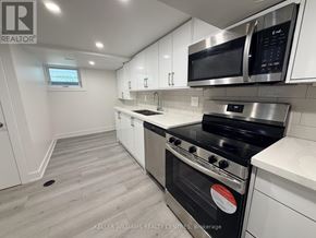 Toronto (Thistletown-Beaumonde Heights) apartment for rent - A modern kitchen with white cabinets and stainless steel appliances.