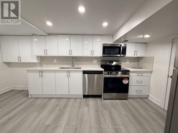Toronto (Thistletown-Beaumonde Heights) apartment for rent - A modern kitchen with white cabinets and stainless steel appliances.