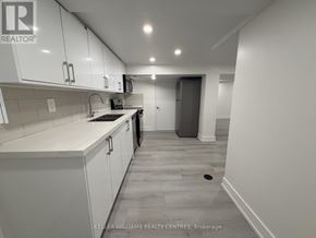 Toronto (Thistletown-Beaumonde Heights) apartment for rent - A kitchen with white cabinets and a tiled backsplash.