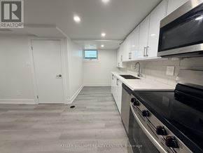 Toronto (Thistletown-Beaumonde Heights) apartment for rent - A kitchen with a stove top oven and microwave above it.