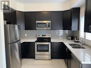 Brant (Paris) apartment for rent - A modern kitchen with black cabinets and stainless steel appliances.