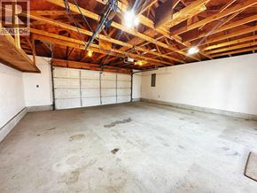North Vancouver apartment for rent - A large empty room with a garage door and exposed wooden beams.
