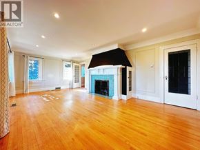 North Vancouver apartment for rent - A large, empty room with wooden floors and a fireplace.