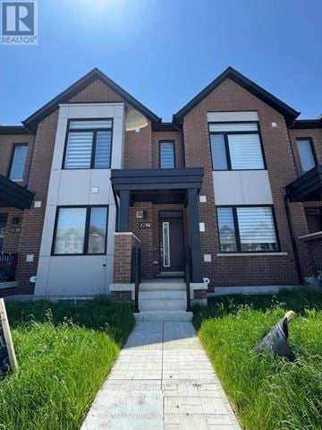 Oakville (Go Glenorchy) townhouse for rent - A modern brick house with a glass entrance door and a small garden in front.