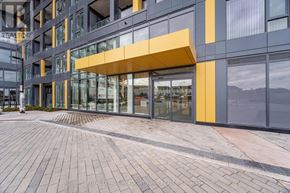 Burlington (Alton) condo for rent - A modern building with a yellow awning and glass windows.