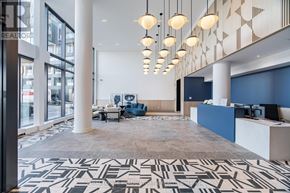 Burlington (Alton) condo for rent - A spacious office lobby with a reception desk and a large patterned carpet.