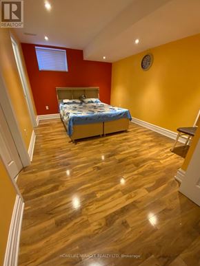 Caledon apartment for rent - A bedroom with a bed, wooden floors, and a window.