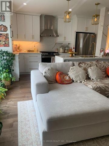 Brampton (Northwood Park) apartment for rent - A living room with a grey couch and a kitchen in the background.