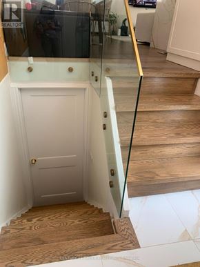 Brampton (Northwood Park) apartment for rent - A white door with a gold handle is in a hallway with a glass railing.