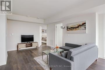 Toronto (Flemingdon Park) condo for rent - A living room with a grey couch and a glass coffee table.