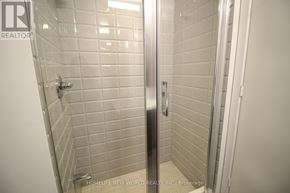 Toronto (Kensington-Chinatown) condo for rent - A white tiled bathroom with a glass door.