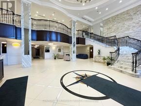Markham (Unionville) condo for rent - A large foyer with a spiral staircase and a large clock on the floor.