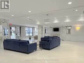 Markham (Unionville) condo for rent - A spacious living room with two blue velvet sofas and a television.