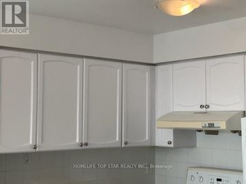 Toronto (Bendale) condo for rent - A kitchen with white cabinets and a white stove top.