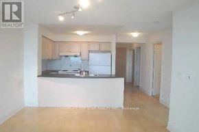 Toronto (Bendale) condo for rent - A realtor photo of a kitchen with white appliances and wooden floors.