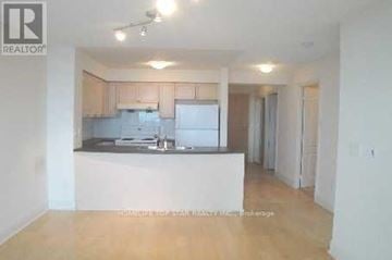 Toronto (Bendale) condo for rent - A realtor photo of a kitchen with white appliances and wooden floors.
