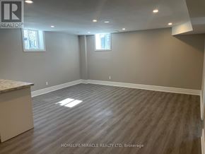 Vaughan (Kleinburg) apartment for rent - A spacious room with wooden flooring and two windows.